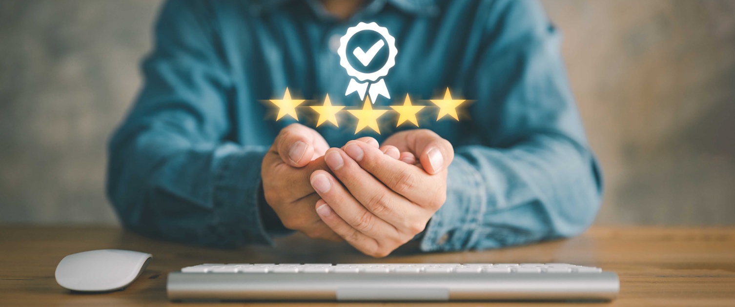 Man sat a desk with his hands open and stars popping out of his hands to resemble quality. 