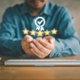 Man sat a desk with his hands open and stars popping out of his hands to resemble quality. 